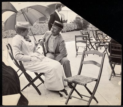 Hombre y mujer sentados afuera en sillas plegables con mujer sosteniendo una sombrilla, Narragansett, Rhode Island, 1891 (impresión de gelatina de plata) de Byron Company